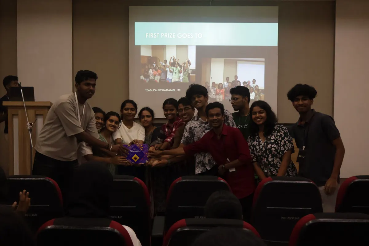 A group gathered on stage in front of a projected slideshow