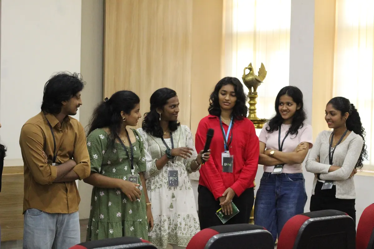Students standing and talking, one holding an award