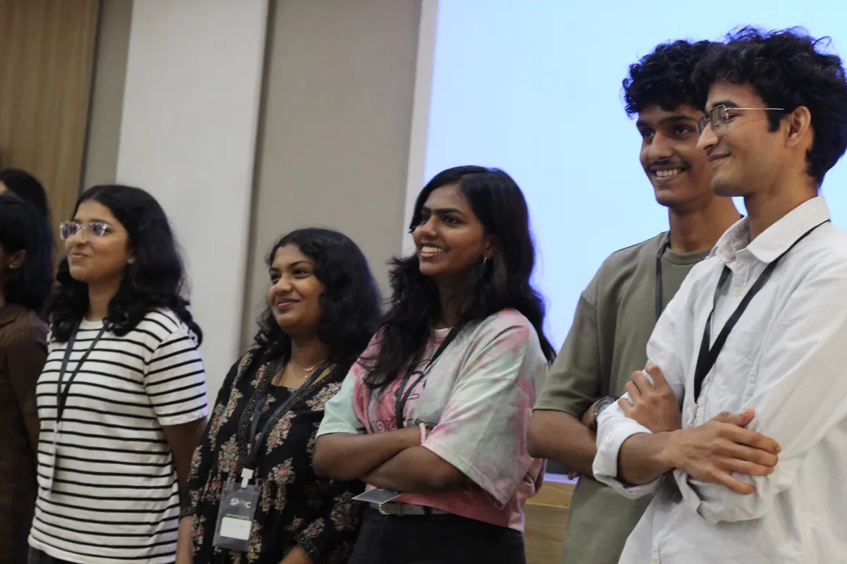 Students laughing together in front of the projector screen