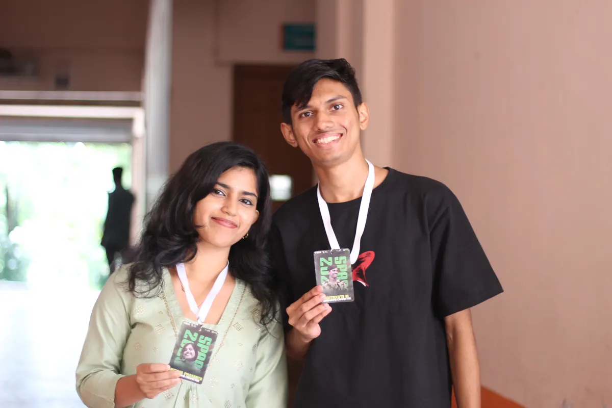 Two students posing with the cards they were handed