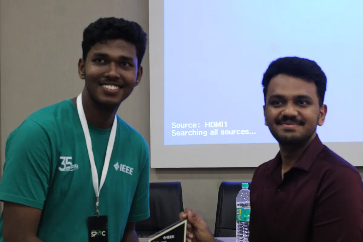 Two students beside the projector screen while the display is set up