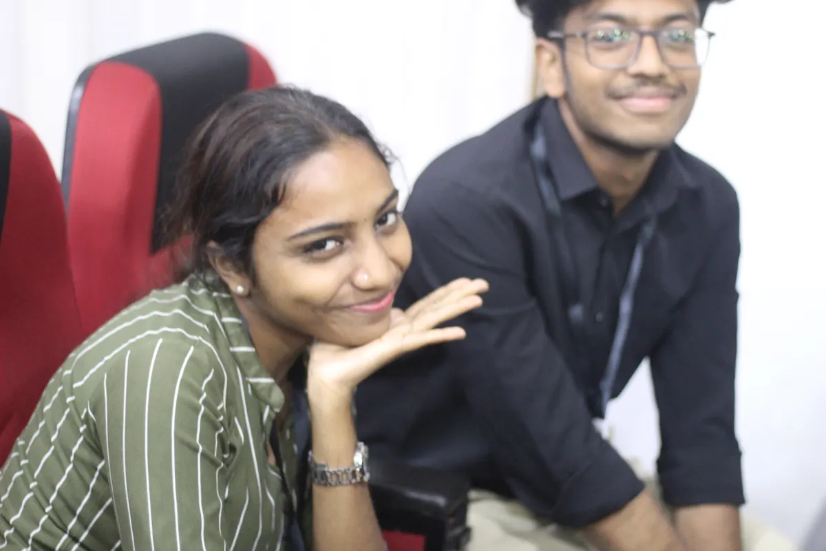Two students smiling close to the camera in the auditorium