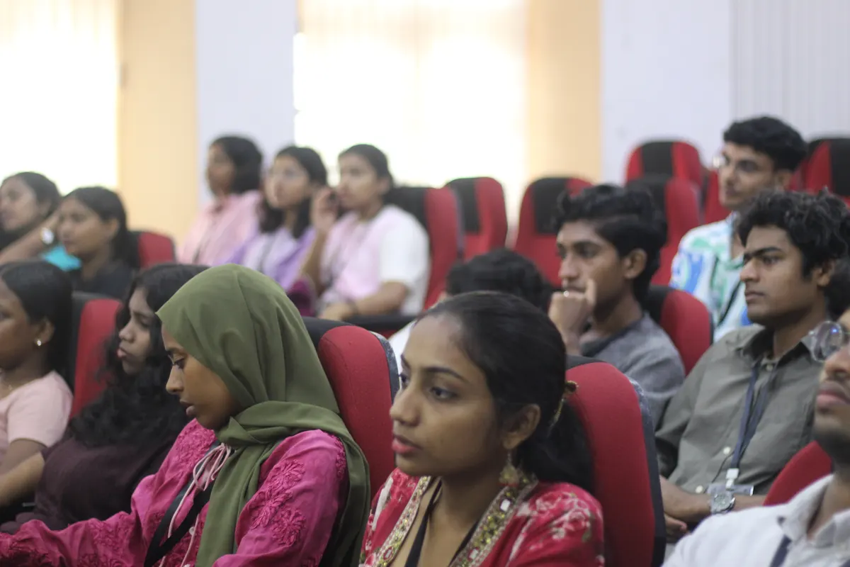 Rows of students listening from the auditorium seats