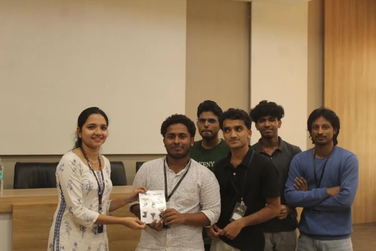 A guest holding a wrapped gift, surrounded by students