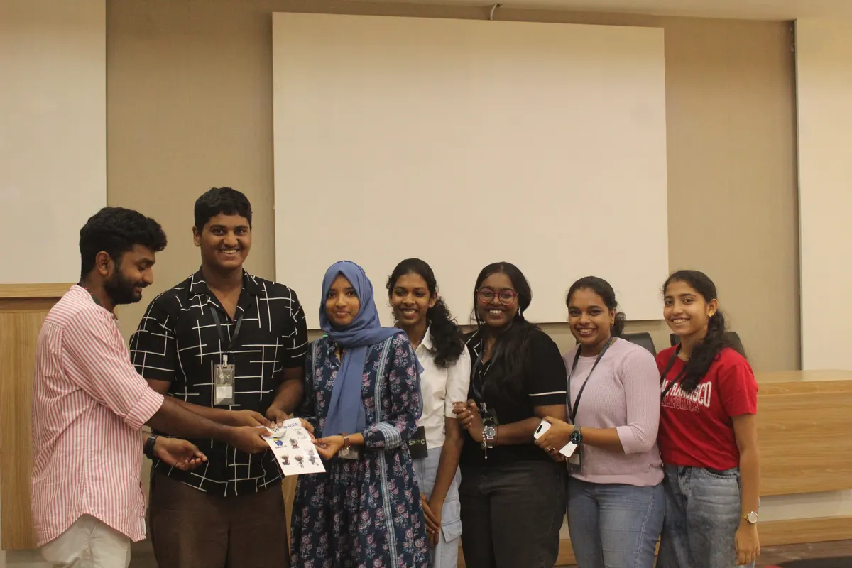 Students posing on stage with their prizes