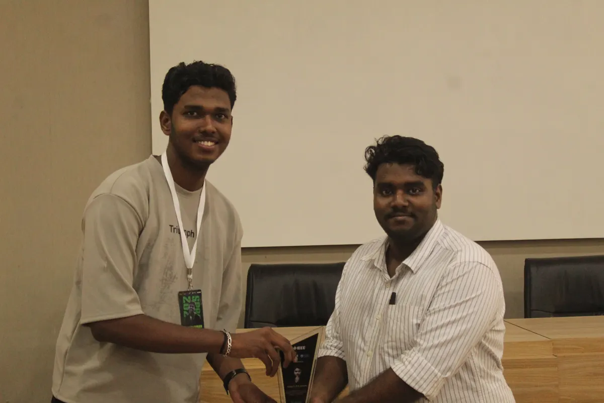 Two students shaking hands as an award changes hands