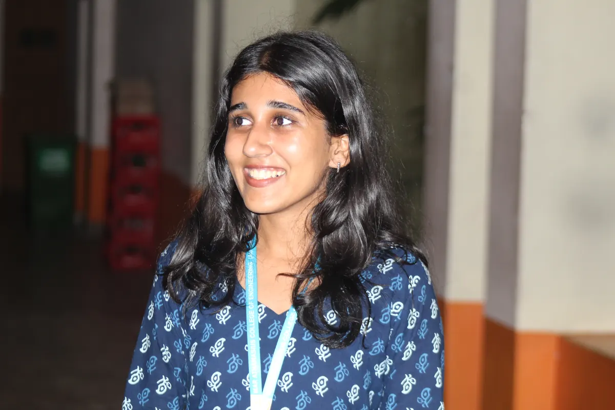 A student smiling in the corridor outside the hall